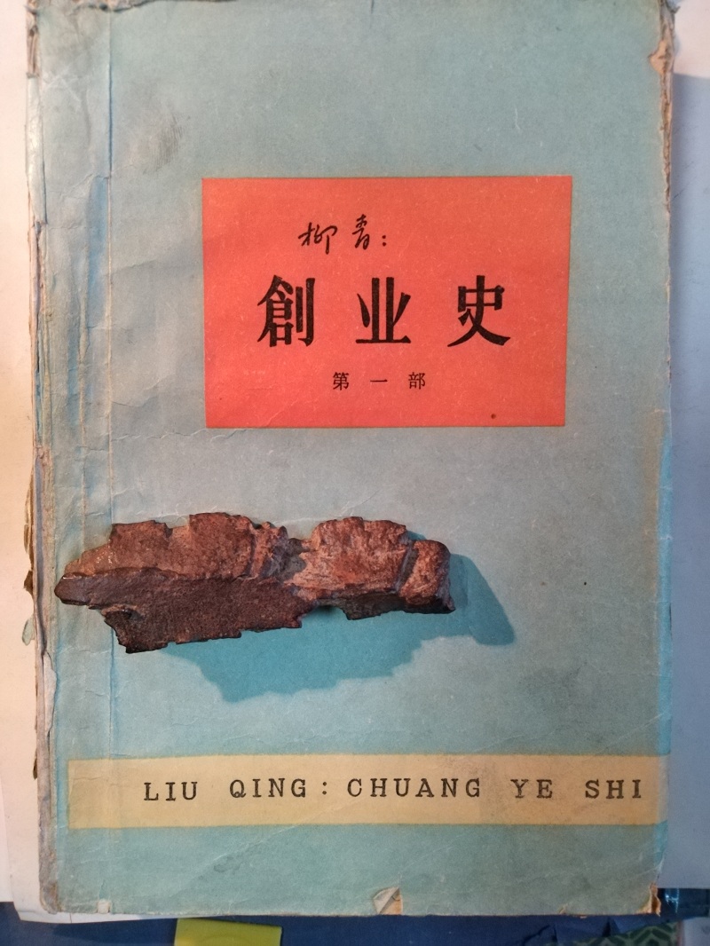 長(zhǎng)篇小說《創(chuàng)業(yè)史》（第一部）書影與柳青曾收藏的彈片。 （文金 攝）